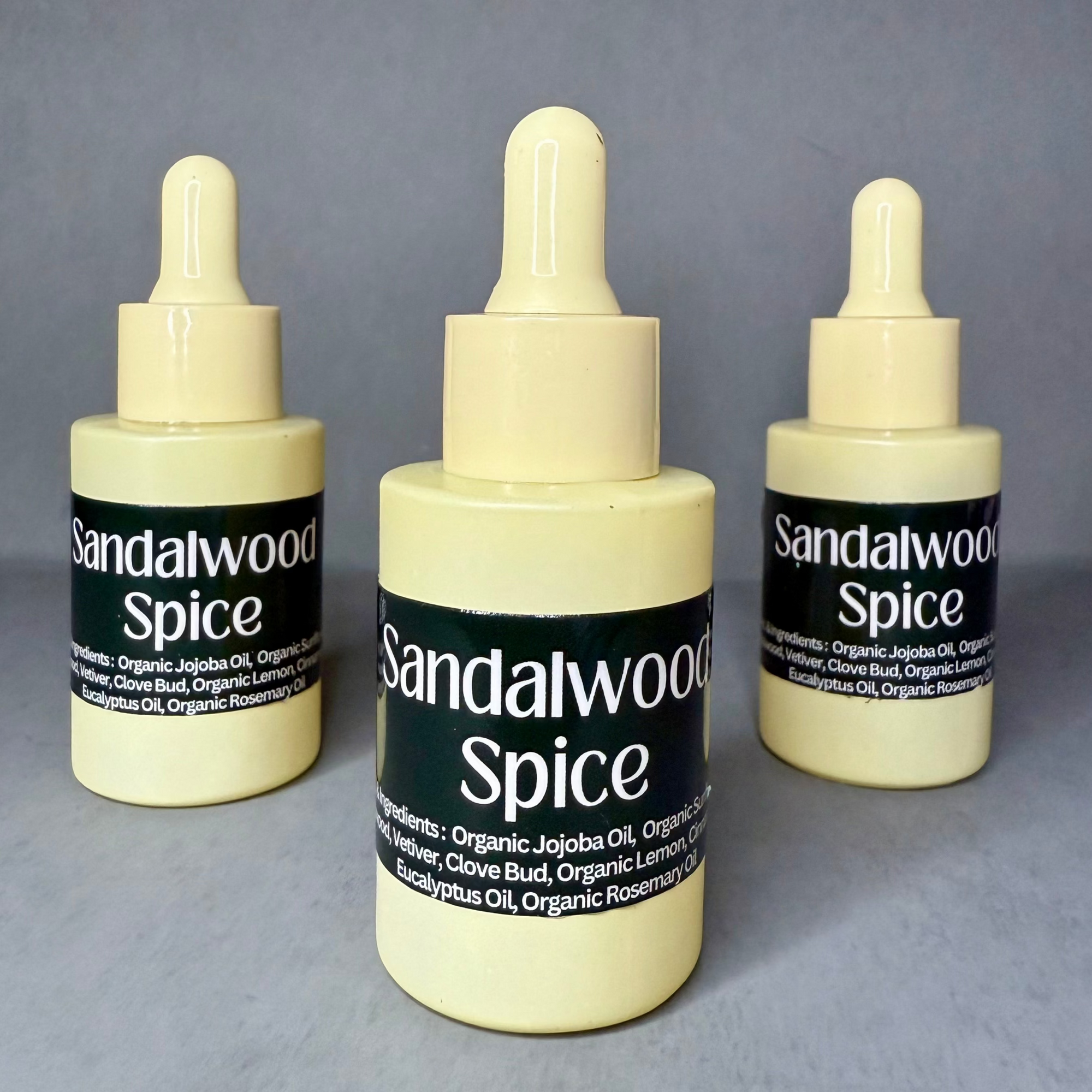 Three bottles of Sandalwood Spice on a gray background